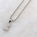 Silver-toned letter K pendant necklace with pave zircon stones on white fur - Silver K
