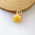 Detailed close-up of an orange slice enamel charm with gold metal loops on wood - Orange Skin Orange Segment (Model #8)