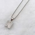 Silver letter N pendant necklace with cubic zirconia on white faux fur background - Silver N