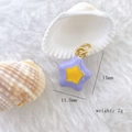Macro shot of a purple enamel star pendant with size specs on a plush background - Star #1