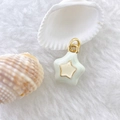 Detail of mint green enamel star pendant with gold star inlay on soft white fur - Star #2