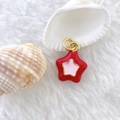 Macro shot of 3D red pentagram star pendant with gold rings on soft white background - Star #5