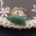 Detalle de anillo en forma de pez con piedra verde y alambre dorado sobre encaje - Aventurina Verde