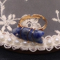 Detalle de anillo artesanal de alambre con gema de pez azul y un pequeño detalle de cristal - Piedra de punto azul