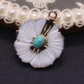 Macro detail of white peach blossom shell pendant with turquoise stone and golden edge - Blue Turquoise