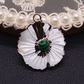 Detailed macro of flower-shaped shell pendant with gold plating and green malachite center - Malachite