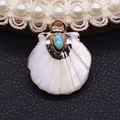 Macro shot of shell pendant with white nacre texture, turquoise stone, and golden metal rim - Blue Turquoise