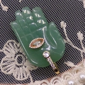 Detailed close-up of green jade Hamsa hand pendant with gold setting and gemstone inlay - 17x32mm / Green Aventurine