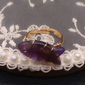 Anillo artesanal de hilo dorado con un pez de cristal púrpura tallado en piedra natural - Amatista
