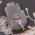 Detailed macro of a gold diamond ring and purple gemstone on a palm-shaped stone stand - 17x32mm / Flash Stone (Labradorite)