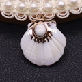 White shell fan-shaped pendant with marble textured stone inlay and gold finish - Howlite