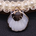 Scallop shell pendant with inlaid dark gray gemstone and golden metal plated edge - Flash Stone (Labradorite)