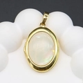 Macro-opname van een vergulde ovale locket met parelmoerinleg op een displaystandaard - 19x28mm (5g) / Wit Parelmoer