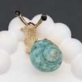 Detailed view of snail brooch with gold texture and turquoise spiral shell on white stand - 20-55mm, 10g / Gold Natural Green Shell
