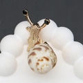 Vista detallada de broche de caracol con cuerpo de aleación dorada y textura de concha - Dorado Concha Caracol Manchada