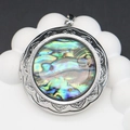 Detailed view of round locket with floral engravings and colorful abalone shell inlay - Round Style / 44x48mm