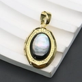Macro shot of oval gold locket with iridescent abalone shell inlay and vintage carvings - Oval Locket / Black Mother of Pearl