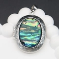 Macro detail of oval abalone shell locket with vintage floral engravings and metal hinge - Oval Design / 39x52mm