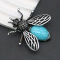Makroaufnahme einer Bienenbrosche mit Vintage-Metallflügeln und Türkisstein-Inlay - Blauer Türkis