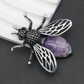 Makro-Detail der Bienenbrosche mit verzierten Flügeln und violettem Edelstein - Amethyst