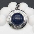 Macro shot of silver locket pendant with round blue lapis stone and engraved details - Lapis Lazuli