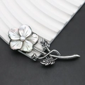 Dettaglio macro di una spilla a fiore vintage con petali in madreperla nera e perla - 32x77mm / Stile 2 (Multipetalo Bianco)