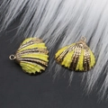 Gros plan de pendentifs coquillages jaunes dorés pour la création de bijoux DIY - Jaune Vif