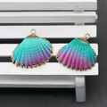 Detail view of colorful shell pendants with gold plated edges on a white bench - Cyan Purple Gradient