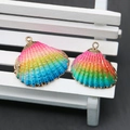 Detailed macro view of vibrant rainbow gradient shell pendants with gold plated edges - Rainbow Gradient