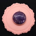 Macro view of a circular purple amethyst pendant featuring a gold-plated metal border frame - Purple Crystal