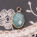 Detailed macro view of an oval turquoise stone pendant on elegant lace and pearls - 11x19mm / Amazonite