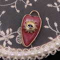 Lapis lazuli heart pendant with golden evil eye design and blue stone accent - Rhodonite