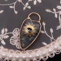 Golden teardrop labradorite pendant featuring a detailed evil eye charm and sunburst design - Labradorite