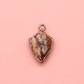Close-up of shield-shaped tiger eye stone pendant with gold-plated metal edge - Jasper / 12x19mm