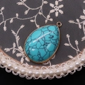 Detailed view of teardrop turquoise pendant with gold plated edge on lace and pearl decor - Blue Turquoise