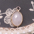 Faceted oval pink quartz pendant with a gold-plated frame and hanging loop charm - 11x19mm / White Crystal