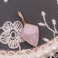 Macro de pendentif en quartz rose facetté avec bélière dorée sur tissu dentelle - Quartz rose