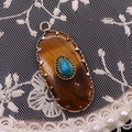Detailed view of vintage oval pendant with turquoise inlay on gold metallic base - 16x36mm, 4g / Tiger's Eye