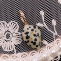 Vue macro du pendentif Jaspe Dalmatien en forme de cerf-volant avec fermoir doré sur dentelle - Jaspe dalmatien