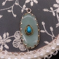 Macro detail of oval green aventurine pendant with blue turquoise inlay and golden frame - 16x36mm, 4g / Green Aventurine