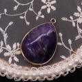 Macro shot of purple teardrop stone pendant with gold plating and natural crystal texture - Purple Crystal