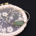 Brazalete dorado ajustable con una gran piedra natural verde ovalada sobre encaje blanco - Aventurina Verde