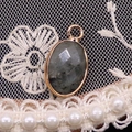 Faceted oval labradorite pendant with gold plated border on elegant lace background - 11x19mm / Labradorite
