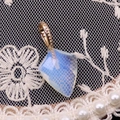 Pendentif losange en opale avec bélière dorée sur fond de dentelle élégante et chic - Opale