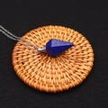 Detailed view of a lapis lazuli hexagonal crystal perfume bottle pendant on a woven mat - Lapis Lazuli