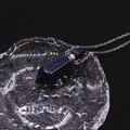 Macro shot of blue sandstone hexagonal perfume bottle necklace on water ripple tray - Blue Sandstone