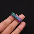 Macro detail of a polished ruby zoisite hexagonal crystal pillar held in fingers - 8x33mm / Ruby Zoisite