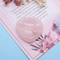Primer plano de piedra de cuarzo rosa en forma de corazón con superficie lisa pulida en tarjeta - Cuarzo rosa