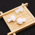 Polished white stone mushroom figurines displayed on a bamboo tray with a zen aesthetic - White Crystal