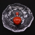 Red heart-shaped essential oil bottle pendant necklace on a rippled glass tray - Red Jasper